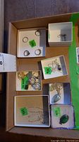 Overview of multiple small boxes containing rings, necklaces and earrings