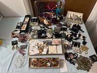 Wide view of multiple pieces of assorted women's jewelry including necklaces, bracelets, earrings, and brooches arranged on a table.
