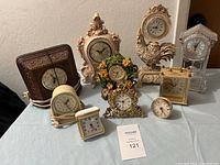 Full view of all 10 clocks displayed on table showing their different styles, materials, and colors.