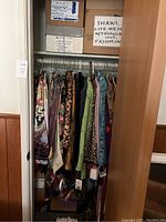 Closet view with patterned garments on hangers and storage boxes above