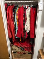 Closet rod loaded with assorted red and patterned women’s outerwear.