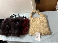 Photo of a cream-colored furry purse and a dark multi-colored furry purse with leather straps on a table.