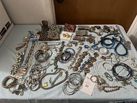 Photo showing full array of bracelets and jewelry laid out on a table, various styles and materials visible.