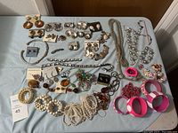 Full overview of the jewelry assortment showing earrings, necklaces, bracelets on table