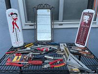 Overall lot showing hand tools, two Betty Boop thermometers, and a decorative mirror