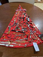 Full overview of all watches and bracelets in lot spread out on a red triangular cloth on table