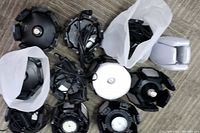 Top-down view showing 11 black folding LED lights arranged in cluster, with white translucent covers and attached cables.