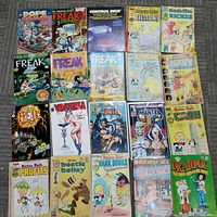 Top view showing full spread of all 20 comics and magazines laid out in rows with visible titles and covers