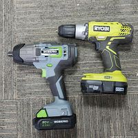 Top view showing Ryobi and WorkPro cordless impact drill wrenches side by side on carpet
