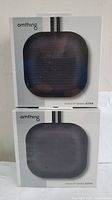 Two Omthing Outdoor Bluetooth speakers in original sealed packaging, front facing view of boxes.