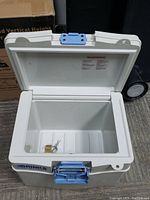 Top view of open Brinks home security safe showing interior and padlock with keys inside.