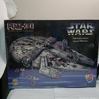 Front of sealed box showing image of completed Millennium Falcon 3D puzzle with Star Wars branding and piece count.