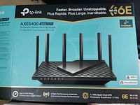 Box front showing Tp-Link Archer AXE5400 tri-band Wi-Fi 6E router with 6 antennas, branding, and key features.