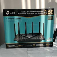 View of the router box showing product branding TP-LINK, model AXE5400 Archer AXE75, and key features including Wi-Fi 6E, OneMesh, WPA3, HomeShield, and 6 high-performance antennas.