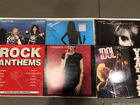 Front cover of six classic rock vinyl records showing artwork for Cheap Trick, Tom Cochrane, Loverboy, Billy Idol, Rock Anthems compilation, and And In Black and White compilation.