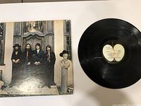 Photo of The Beatles Hey Jude vinyl LP record next to the album cover showing front side and label.