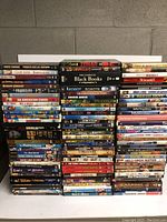 Photo showing a large stack of DVD cases arranged in multiple columns with visible titles.
