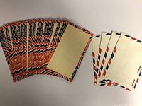 Multiple loose vintage air mail envelopes fanned out showing their front side with red, white, and blue borders and blank writing space