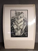 Full view of the Tower of Babel poster by Escher mounted on cardboard, showing the detailed black and white artwork and some bending in the cardboard backing.