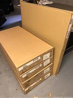 Stacked boxes: one large table box and four smaller chair boxes