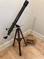 Full view of the Swift Aerolite Model 863 telescope mounted on a wood tripod, showing the long optical tube and mount.