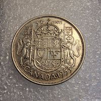 Reverse side of the 1953 Canadian fifty cent coin showing the Canadian coat of arms and denomination.
