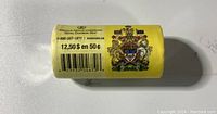 Side view of a yellow paper roll wrapper showing $12.50 in 50 cent coins, with Canadian Coat of Arms and barcode.