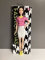 Front view of Fashionistas Barbie #30 doll in box showing the doll wearing pink gingham top, white skirt, yellow shoes and necklace.