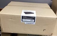 Closed cardboard box with a printed label describing the 5 units in the lot