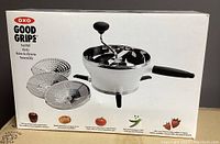 Front of box showing the OXO Good Grips Food Mill with three stainless steel discs and a hand crank mechanism with black handle and knob.