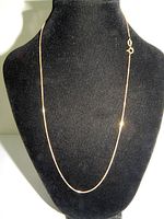 Front view of thin 18-inch 24k gold over sterling silver chain displayed on a black bust stand showing the full length and clasp.