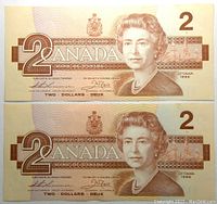 Front side of two 1986 Canada $2 banknotes showing Queen Elizabeth II portrait and denomination.