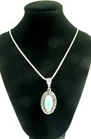 Full view of silver chain necklace with pendant on black display bust for scale and presentation.