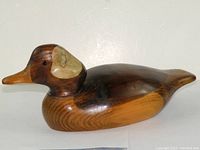 Side angle view of the hand carved wooden duck showing color variations and detailed carving on head and body.