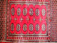 Full top view of the vintage Afghan rug showing central floral medallions and surrounding geometric borders.