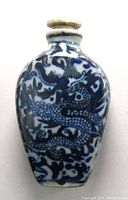 Full view of the ceramic snuff bottle showing detailed blue dragon motif hand painted on white ceramic body with oval shape.