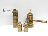 Full set showing four brass kitchenware items against a plain background: pepper mill with crank, coffee maker with handle, salt and pepper containers.