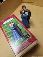 Photo of the Hallmark Keepsake Ornament "Lucy Is Enceinte" 2000 in box, showing front and side of box with ornament inside.