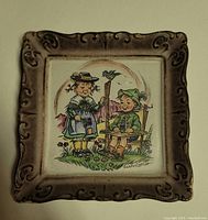 Square Hanitzsch porcelain wall plaque circa 1950 with Bavarian children image and decorative brown border.