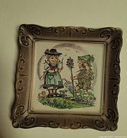 Porcelain wall plaque showing two Bavarian children in traditional attire with decorative raised frame.