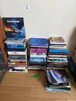 Stack of natural history and fossil science books with varied titles visible including 'Our Universe', 'The Burgess Shale', 'Fundamentals of Paleontology', and others.