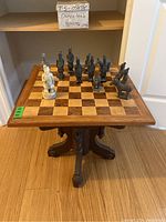 Front view of oak chess table with figurines arranged on board