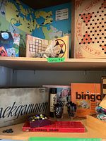 Shelf view showing vintage board games including Backgammon, Bingo, Chinese Checkers, Cribbage board and pieces.