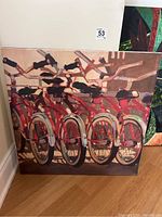 Front view of canvas print showing a group of red bicycles and their shadows.