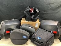 Overall view showing all bags and helmet with boxes on table.