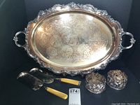 Full view of entire 5-piece silverplate entertaining set against black background.