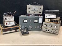 Full group shot showing stack of power supplies, multimeter at left, battery eliminator center, amplifier front and signal generators at right.