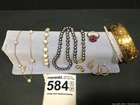 All 10 pieces displayed on jewelry stand against dark background