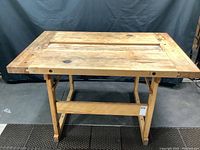 Front view of the maple butcher block work bench with solid wooden legs and cross braces.