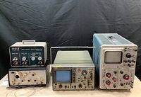 Overview of five instruments on table: Cenco sweep generator, MCM meter, portable scope, and other generators